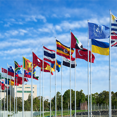 International flags flying against a blue sky.